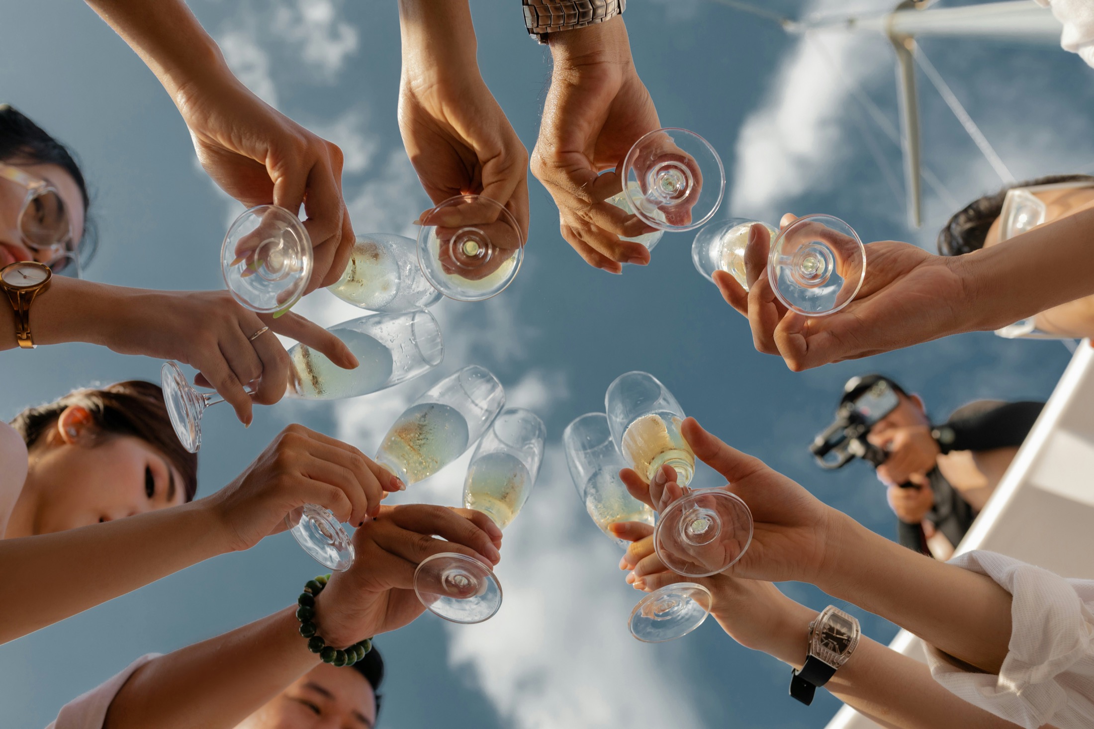 Guests raising wine glasses outdoors under the sky